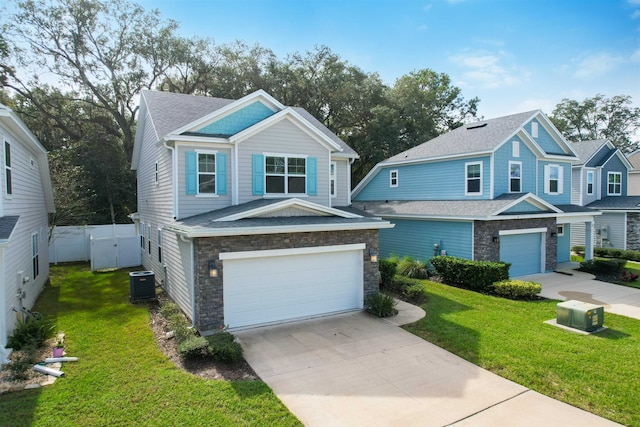 view of front of home featuring a garage, a front yard, and central AC