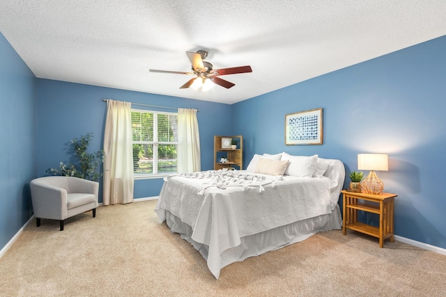 carpeted bedroom with baseboards, ceiling fan, and a textured ceiling