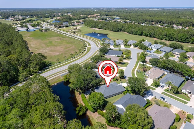 aerial view of property and surrounding area featuring a nearby body of water and nearby suburban area