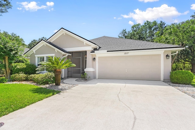 ranch-style house featuring concrete driveway, an attached garage, stucco siding, a front lawn, and a shingled roof