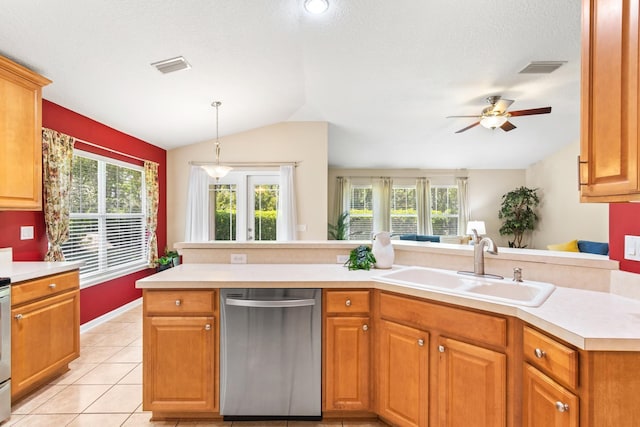 kitchen featuring stainless steel dishwasher, lofted ceiling, a sink, light countertops, and plenty of natural light