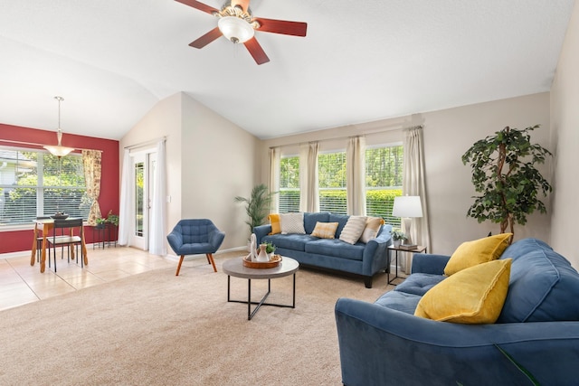 living area with lofted ceiling, baseboards, healthy amount of natural light, a ceiling fan, and light tile patterned floors