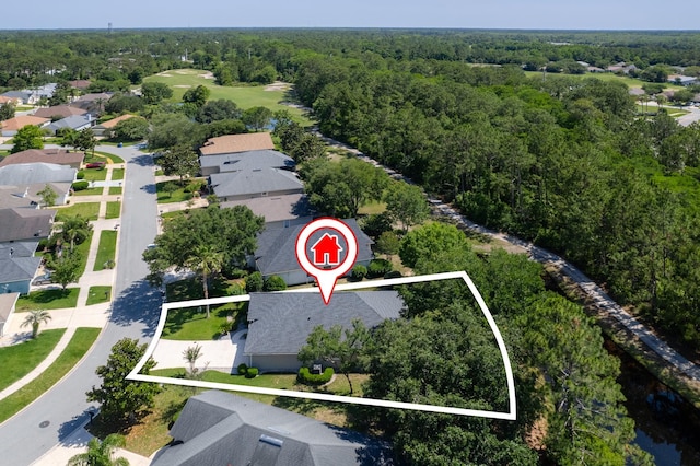 aerial perspective of suburban area with property parcel outlined and a heavily wooded area