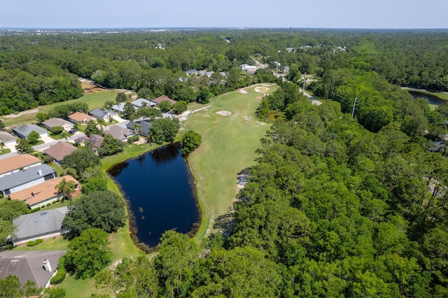 aerial view of property and surrounding area featuring a heavily wooded area, a nearby body of water, nearby suburban area, and a golf course