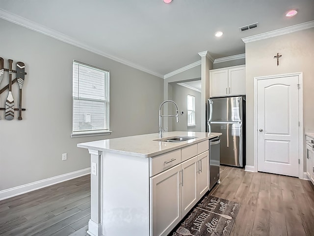 kitchen with a sink, stainless steel appliances, light wood-style floors, white cabinets, and light countertops