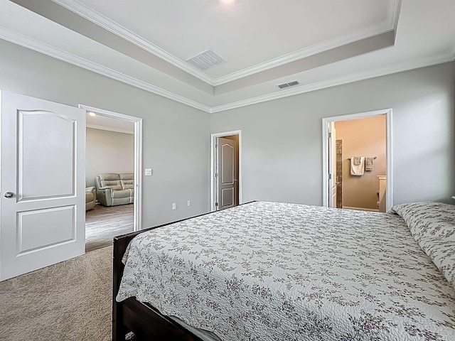 carpeted bedroom featuring ornamental molding, a raised ceiling, and ensuite bathroom