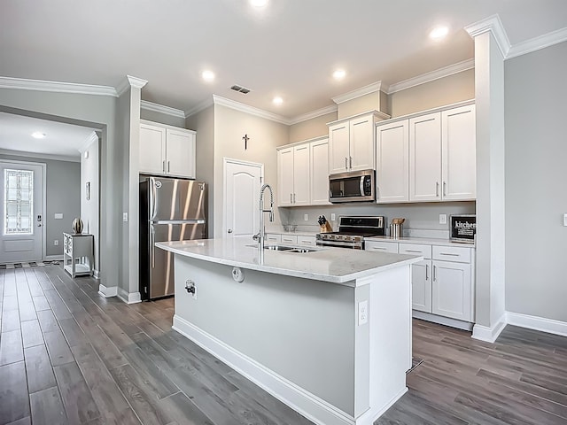 kitchen featuring stainless steel appliances, a sink, crown molding, dark wood-type flooring, and baseboards
