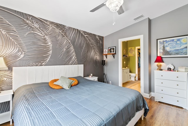 bedroom featuring connected bathroom, light hardwood / wood-style floors, ceiling fan, and lofted ceiling