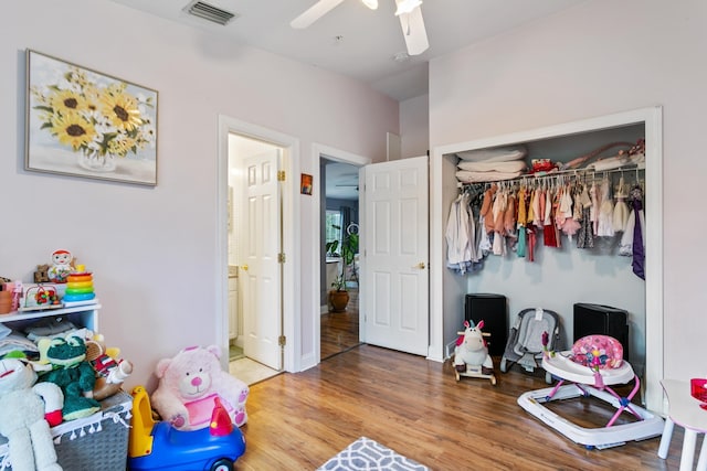 interior space with ceiling fan, wood-type flooring, and a closet