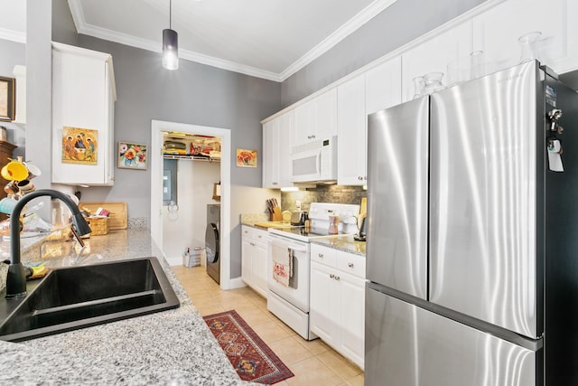 kitchen with light stone countertops, white appliances, sink, light tile patterned floors, and hanging light fixtures