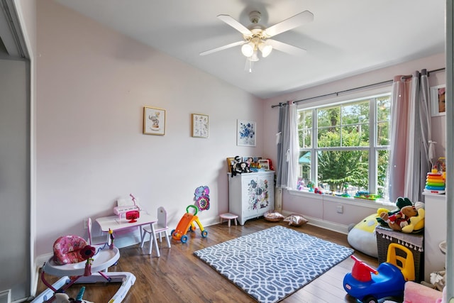 playroom with ceiling fan, dark wood-type flooring, and vaulted ceiling