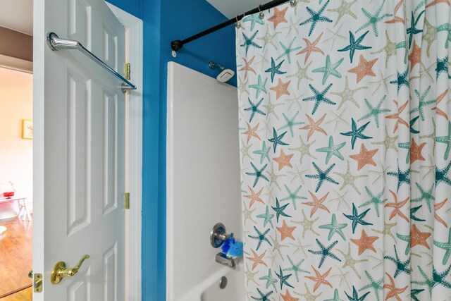 bathroom featuring shower / bath combination with curtain and hardwood / wood-style floors