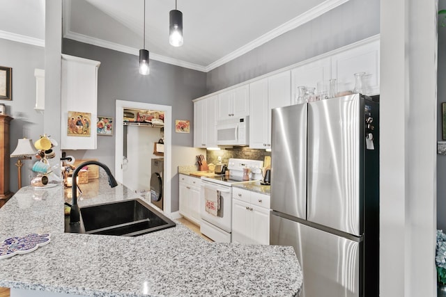 kitchen with sink, light stone counters, washer / clothes dryer, pendant lighting, and white appliances