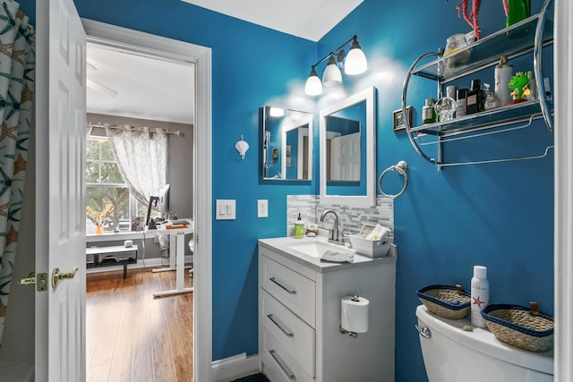 bathroom with hardwood / wood-style floors, vanity, toilet, and backsplash