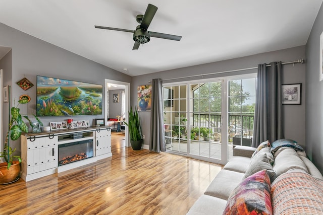 living room featuring light hardwood / wood-style flooring, vaulted ceiling, and ceiling fan