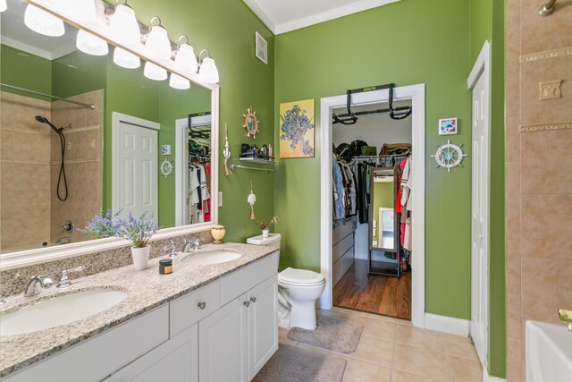 bathroom featuring tile patterned floors, crown molding, vanity, and toilet