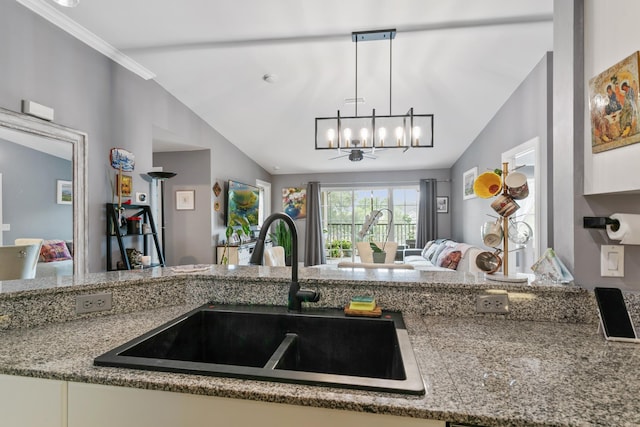 kitchen with stone countertops, sink, decorative light fixtures, vaulted ceiling, and a notable chandelier