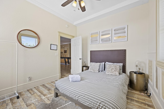 bedroom featuring ceiling fan, ornamental molding, and light hardwood / wood-style flooring