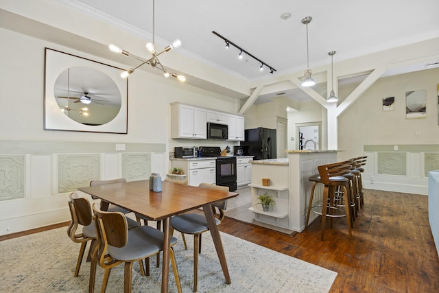 dining area with beam ceiling, ceiling fan with notable chandelier, dark hardwood / wood-style floors, and sink