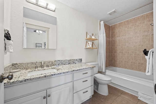 full bathroom featuring vanity, tile patterned flooring, toilet, a textured ceiling, and shower / tub combo