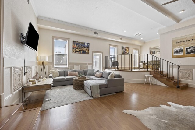 living room with hardwood / wood-style floors and crown molding