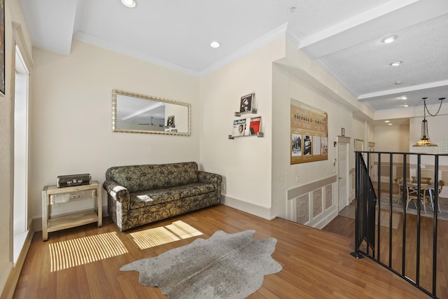 sitting room with hardwood / wood-style floors and crown molding