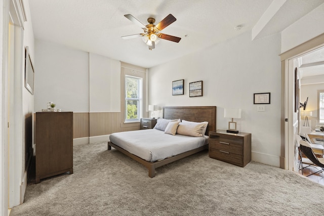 carpeted bedroom featuring ceiling fan and a textured ceiling