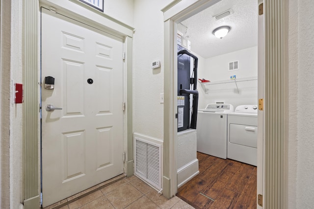 interior space with dark hardwood / wood-style floors, washer and dryer, and a textured ceiling