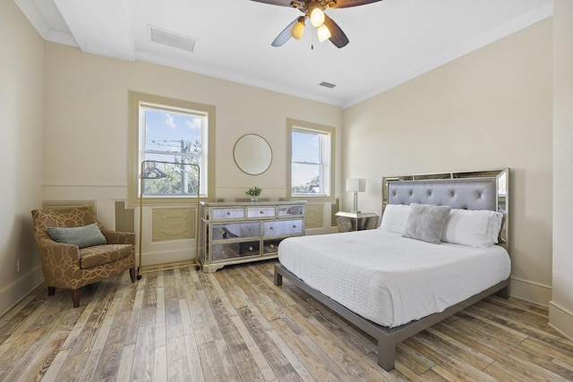 bedroom featuring ceiling fan, crown molding, and light hardwood / wood-style floors