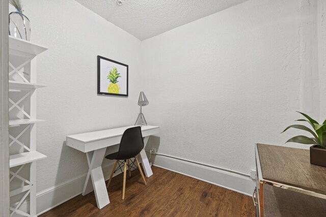 office area with a textured ceiling and dark hardwood / wood-style floors