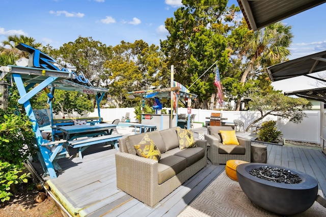 deck with a fenced in pool and an outdoor living space with a fire pit
