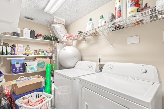 laundry room with separate washer and dryer and a textured ceiling