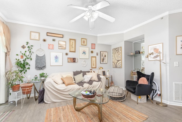 living room featuring a textured ceiling, hardwood / wood-style flooring, and ornamental molding