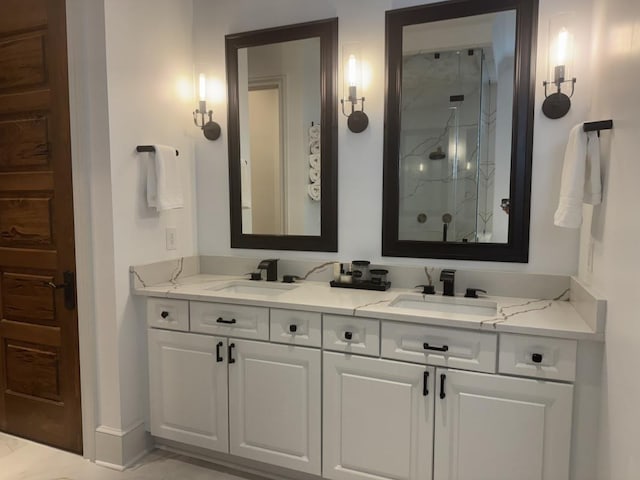 full bathroom with double vanity, a sink, and a marble finish shower