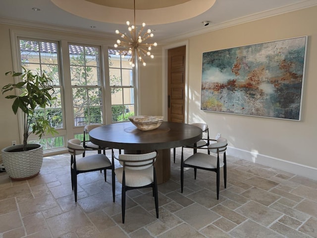 dining room featuring stone tile floors, a tray ceiling, a wealth of natural light, and ornamental molding