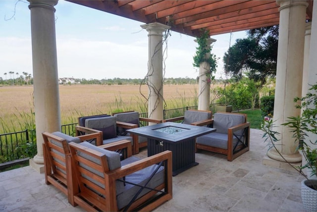 view of patio / terrace with an outdoor living space with a fire pit, a pergola, and a rural view