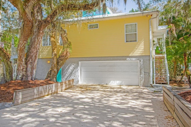 1440 Corunna St, Saint Augustine, FL 32080 - view of front of house with stucco siding, driveway, a garage, and stairs