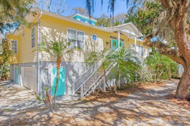 1440 Corunna St, Saint Augustine, FL 32080 - view of home's exterior featuring stairs, a porch, an attached garage, and driveway