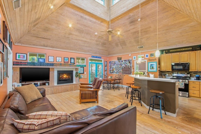 1440 Corunna St, Saint Augustine, FL 32080 - living area featuring light wood-type flooring, visible vents, wood ceiling, and a warm lit fireplace
