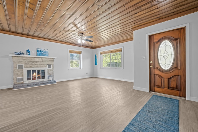 entryway featuring light wood-type flooring, ceiling fan, a fireplace, and wooden ceiling