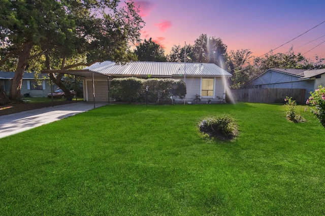 ranch-style home featuring metal roof, concrete driveway, and a carport