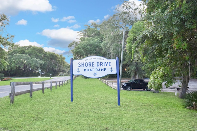 community / neighborhood sign featuring a lawn