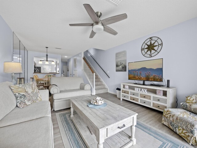 living room with ceiling fan and hardwood / wood-style floors