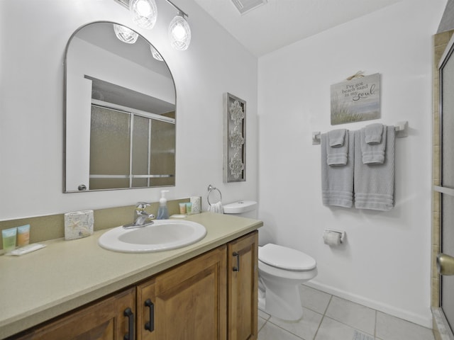 bathroom featuring toilet, vanity, tile patterned floors, and an enclosed shower