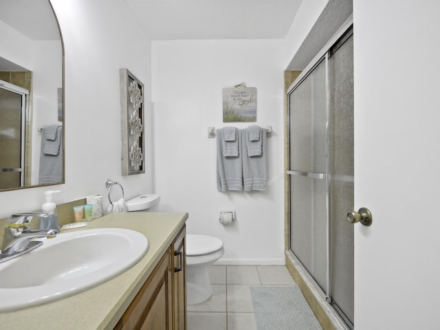 bathroom with tile patterned flooring, vanity, toilet, and an enclosed shower