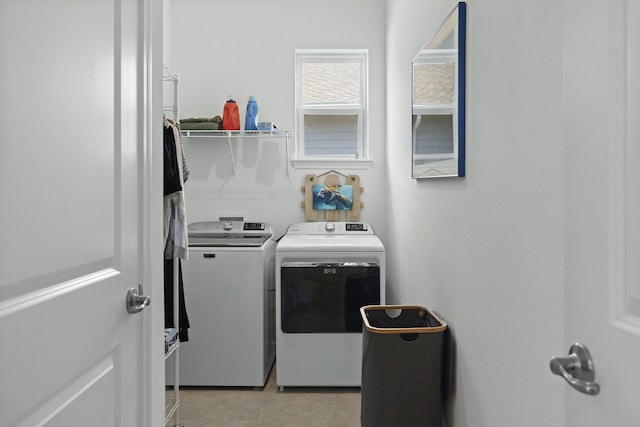 clothes washing area featuring light tile patterned flooring and washer and dryer