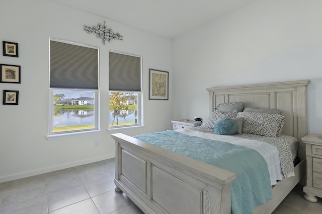 bedroom with a water view and light tile patterned floors