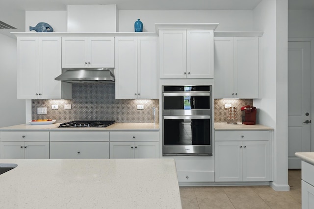 kitchen featuring double oven, black gas cooktop, white cabinets, and ventilation hood