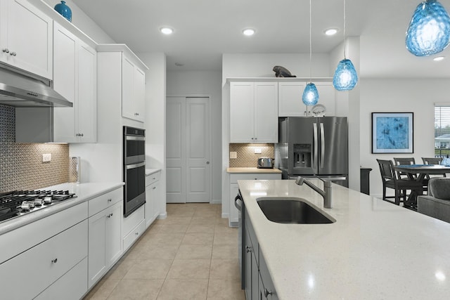 kitchen featuring white cabinets, appliances with stainless steel finishes, pendant lighting, and sink