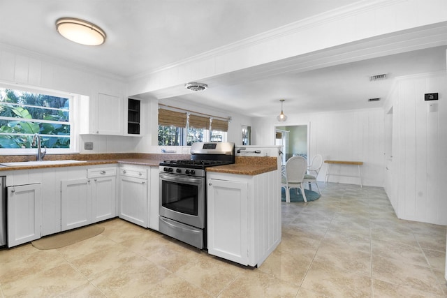 kitchen featuring a healthy amount of sunlight, stainless steel gas stove, white cabinets, and sink